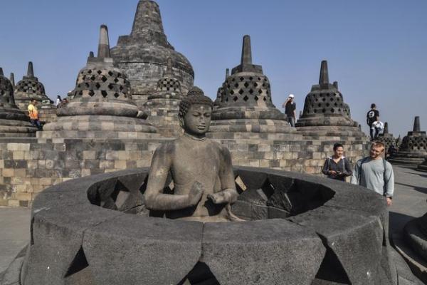 Turis asing sedang mengamati patung di Candi Borobudur (foto: cnbcindonesia.com) 