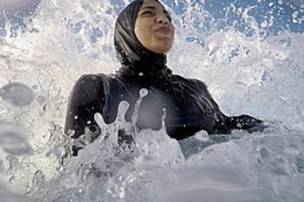 Ilustrasi - seorang wanita mengenakan burkini saat berenang di ombak (Foto: Wikipedia) 