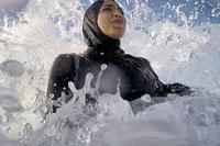 Ilustrasi - seorang wanita mengenakan burkini saat berenang di ombak (Foto: Wikipedia)