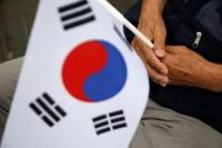 Seorang veteran perang Korea Selatan memegang bendera nasional selama upacara memperingati 70 tahun Perang Korea, di Cheorwon, Korea Selatan, 25 Juni 2020. Foto: Reuters