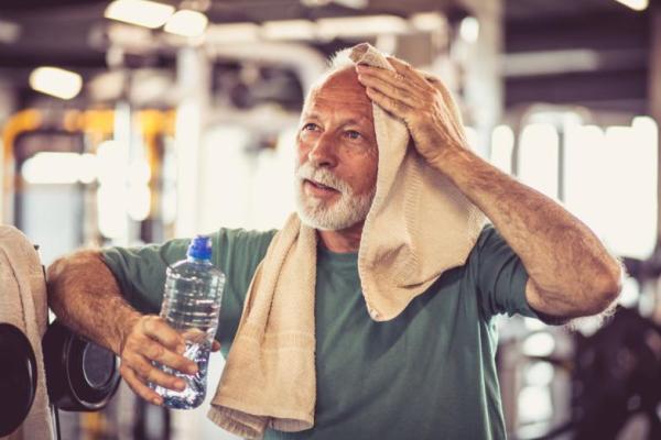 Pria tua menyeka keringat dari latihan yang intens di gym (Foto: Mladen Zivkovic, Shutterstock) 