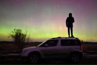 Seseorang berdiri di atas mobil sambil melihat Aurora di wilayah barat daya Siberia Omsk, Rusia 6 November 2023. Foto: Reuters