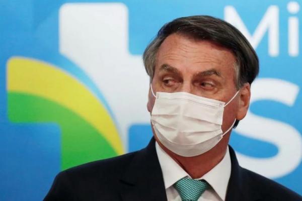 Presiden Brasil Jair Bolsonaro menyaksikan upacara penandatanganan Perjanjian Transfer Teknologi Vaksin COVID-19 Oxford-AstraZeneca, di Brasilia, Brasil, 1 Juni 2021. Foto: Reuters 