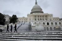 Orang-orang berjalan melewati gedung US Capitol yang bersalju di Washington, AS, 16 Januari 2024. Foto: Reuters