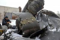 Seorang pria memotret bagian-bagian dari rudal tak dikenal, di Kharkiv, Ukraina 6 Januari 2024 REUTERS