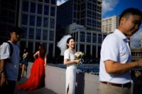 Pasangan bersiap untuk pemotretan pernikahan di jalan, di Shanghai, Tiongkok 6 September 2023. REUTERS