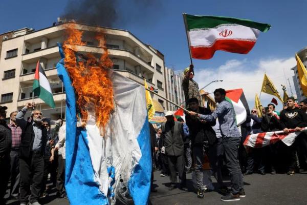 Warga Iran  membakar bendera Israel saat unjuk rasa memperingati Hari Quds, di Teheran, Iran, 5 April 2024. WANA via REUTERS 