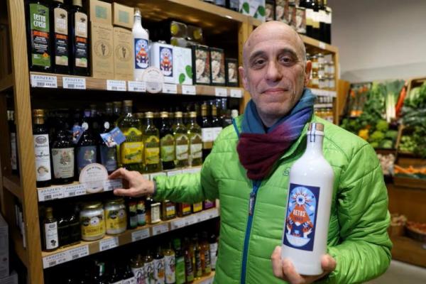 David Josephs, pemilik Panzers, memegang sebotol minyak zaitun artisan saat dia berpose untuk toko makanan di London, Inggris, 26 Maret 2024. REUTERS 