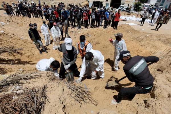 Orang-orang bekerja untuk memindahkan jenazah warga Palestina yang tewas selama serangan militer Israel di Khan Younis di Jalur Gaza selatan, 21 April 2024. REUTERS 