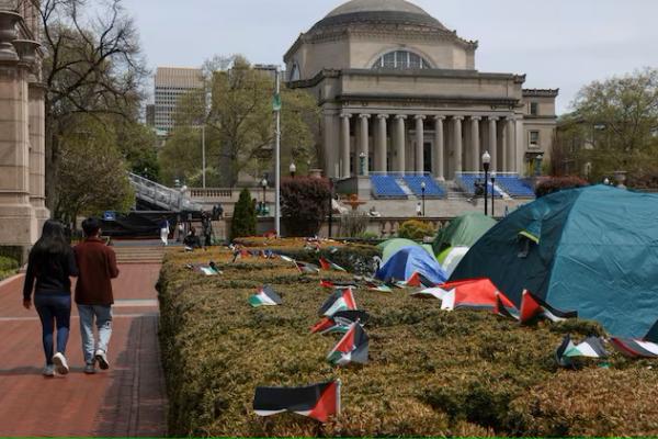 Mahasiswa berjalan melewati perkemahan protes di kampus utama Universitas Columbia yang mendukung Palestina, di New York City, AS, 27 April 2024. REUTERS 