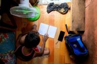Seorang siswa menjawab modul pembelajarannya setelah penangguhan kelas tatap muka, di dalam rumahnya di Manila, Filipina, 26 April 2024. REUTERS