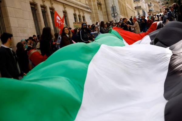 Para mahasiswa memegang bendera raksasa Palestina saat mereka berkumpul di dekat Universitas Sorbonne untuk mendukung warga Palestina di Gaza, di Paris, Prancis, 29 April 2024. REUTERS 