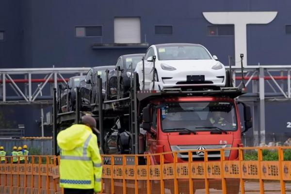 Sebuah truk mengangkut mobil Tesla baru di pabriknya di Shanghai, Cina, 13 Mei 2021. REUTERS 