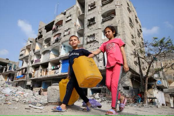 Anak-anak Palestina berjalan melewati sebuah rumah yang rusak akibat serangan Israel, di Rafah, di selatan Jalur Gaza, 1 Mei 2024. REUTERS 