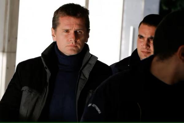 Alexander Vinnik, pria Rusia yang dicurigai menjalankan operasi pencucian uang menggunakan bitcoin, dikawal oleh petugas polisi ke pengadilan di Athena, Yunani 13 Desember 2017. REUTERS 