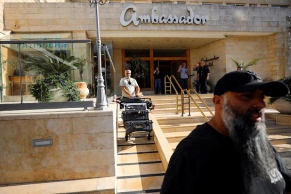 Seorang pria melakukan manuver peralatan media menyusul penggerebekan polisi Israel di kantor de facto Al Jazeera di Hotel Ambassador di Yerusalem, 5 Mei 2024. REUTERS 