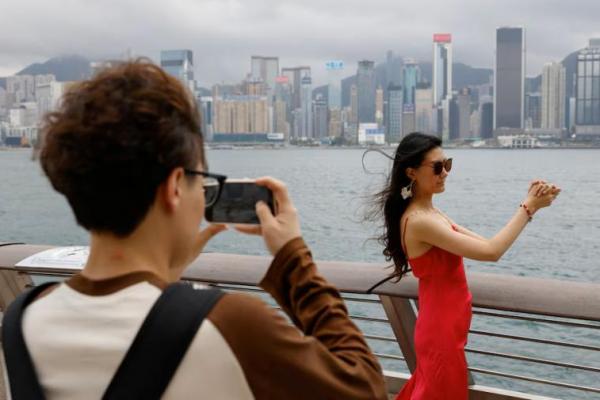 Laura Li, 28, berpose untuk foto di depan Pelabuhan Victoria, sehari menjelang liburan Hari Buruh Tiongkok, di Hong Kong, Tiongkok 30 April 2024. REUTERS 