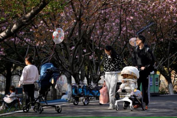 Seseorang mendorong kereta bayi di sebuah taman di Shanghai, Tiongkok, 2 April 2023. REUTERS 
