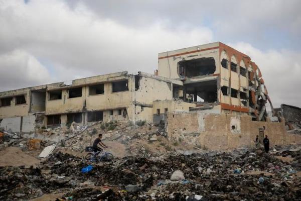 Warga Palestina melewati sebuah sekolah yang hancur akibat serangan militer Israel, di Kota Gaza 28 April 2024. REUTERS 