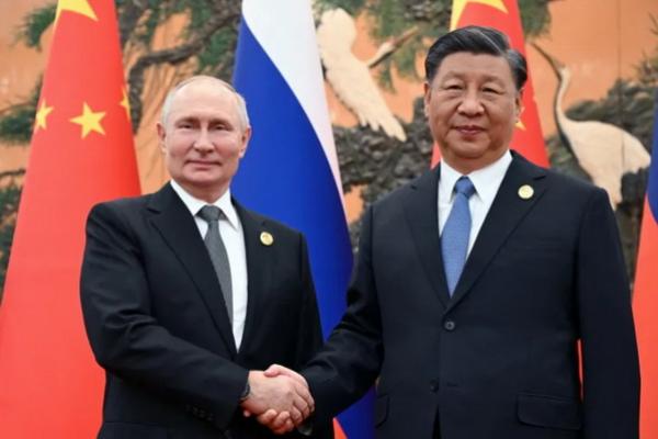 Presiden Rusia Vladimir Putin berjabat tangan dengan Presiden Tiongkok Xi Jinping selama pertemuan di Belt and Road Forum di Beijing. (FOTO: REUTERS) 