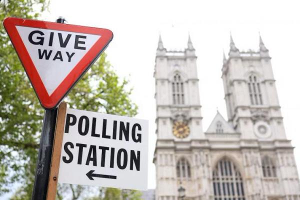 Tanda arah tempat pemungutan suara terpasang pada tanda jalan dekat Westminster Abbey, menjelang pemilihan lokal, di London, Inggris, 1 Mei 2024. REUTERS 