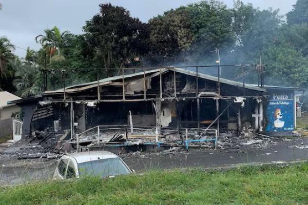 Sebuah bangunan rusak saat perusuh memprotes perubahan aturan pemungutan suara yang ditolak oleh pengunjuk rasa adat Kanak, di Noumea, Kaledonia Baru, 15 Mei 2024. Foto via Reuters REUTERS 