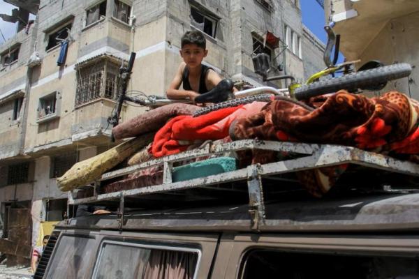 Seorang anak laki-laki Palestina duduk di atas kendaraan yang penuh dengan barang-barang saat ia kembali ke rumahnya di lingkungan Zeitoun di Kota Gaza, 15 Mei. REUTERS 