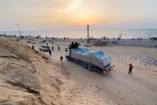 Sebuah truk yang membawa bantuan dikirim ke Gaza melalui dermaga buatan AS bergerak, terlihat dari tengah Jalur Gaza, dalam gambar diam yang diambil dari video, 17 Mei 2024. REUTERS 