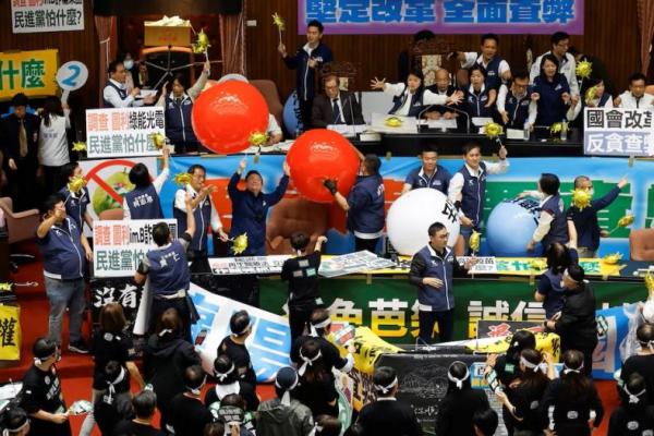 Anggota parlemen mengambil bagian dalam sesi sambil memegang balon tiup, di Parlemen di Taipei, Taiwan 28 Mei 2024. REUTERS 