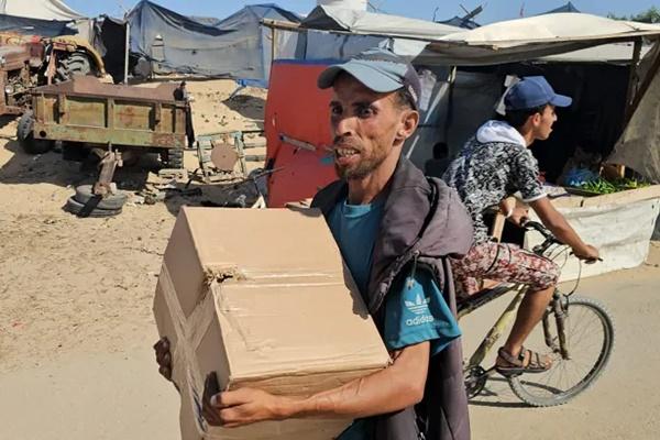 Seorang pengungsi Palestina menerima paket makanan dari yayasan yang didukung AS yang berjanji untuk mendistribusikan bantuan kemanusiaan di Rafah, Gaza selatan. (FOTO: AFP)