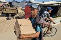 Seorang pengungsi Palestina menerima paket makanan dari yayasan yang didukung AS yang berjanji untuk mendistribusikan bantuan kemanusiaan di Rafah, Gaza selatan. (FOTO: AFP)