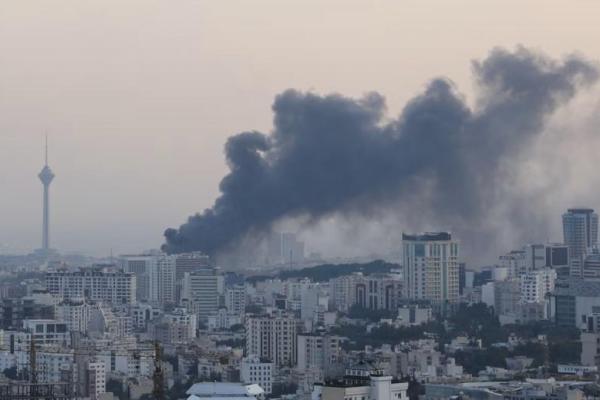 Asap mengepul menyusul serangan Israel terhadap gedung IRIB, lembaga penyiaran negara, di Teheran, Iran, 16 Juni 2025. WANA via REUTERS 