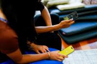 Dua siswa sekolah berpose dengan ponsel mereka yang memperlihatkan aplikasi media sosial di Melbourne, Australia, 28 November 2024. REUTERS