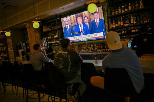 Pengunjung Chapel Street Cafe menyaksikan saat Presiden AS Donald Trump menyampaikan pidato setelah serangan AS terhadap fasilitas nuklir Iran, di Chicago, Illinois, AS, 21 Juni 2025. REUTERS 