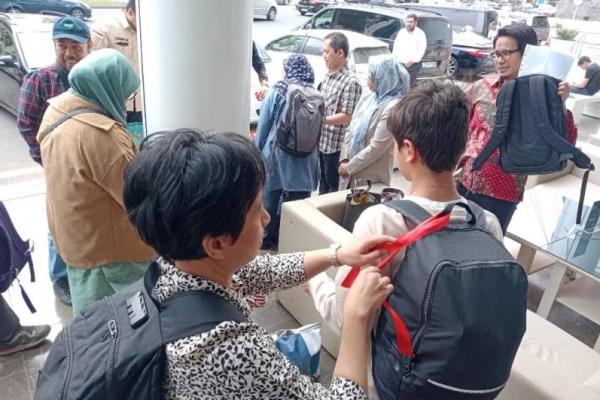 Warga Negara Indonesia (WNI) yang dievakuasi diberi tanda pita merah, sebelum terbang dari Azerbaijan ke Indonesia. Foto: dok. katakini.com 