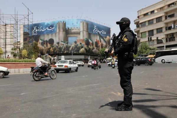 Seorang penjaga keamanan berdiri di jalan, pada dini hari gencatan senjata, di Teheran, Iran, 24 Juni 2025. WANA via REUTERS 