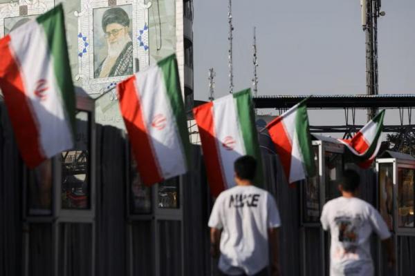 Orang-orang berjalan di dekat mural Pemimpin Tertinggi Iran, Ayatollah Ali Khamenei, di Teheran, Iran, 23 Juni 2025. WANA via REUTERS 