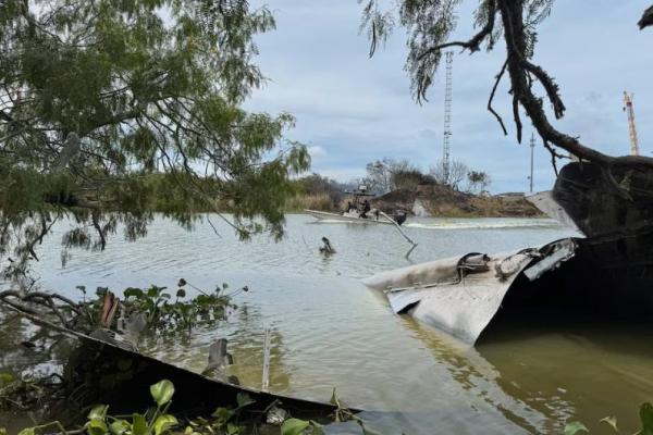 Puing-puing dari pesawat ruang angkasa SpaceX sebagian terendam di Sungai Rio Grande, seperti yang terlihat dari Matamoros, Meksiko, 19 Juni 2025. REUTERS 