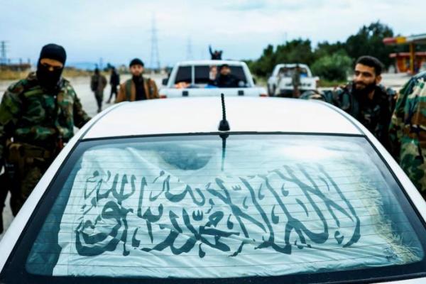 Pasukan keamanan Suriah berdiri di samping sebuah kendaraan di jalan raya Latakia-Jablah di Suriah barat pada tanggal 21 Maret 2025. REUTERS 