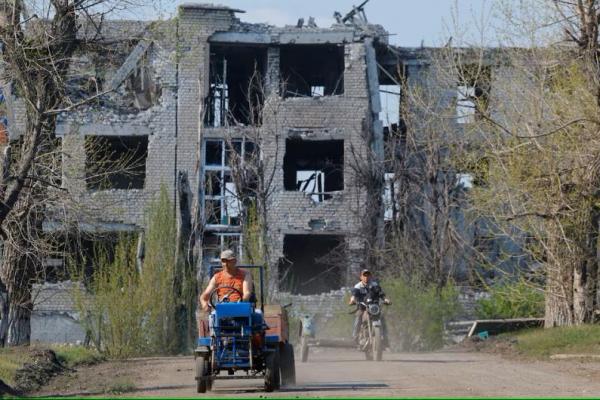 Pria mengendarai kendaraan di dekat bangunan yang hancur selama konflik Rusia-Ukraina di Toshkivka di wilayah Luhansk, wilayah Ukraina yang dikuasai Rusia, 17 April 2025. REUTERS 
