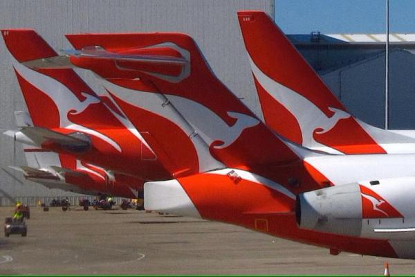 Seorang anggota staf darat melewati sekelompok pesawat Qantas yang diparkir di Terminal Domestik Qantas di Bandara Sydney, Australia, 26 Juli 2016. REUTERS 