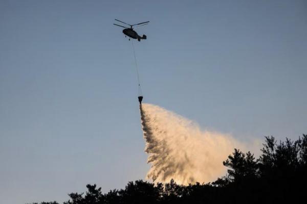 Helikopter pemadam kebakaran menjatuhkan air di salah satu kantong terakhir kebakaran hutan dekat Ierapetra, di pulau Kreta, Yunani, 4 Juli 2025. REUTERS 