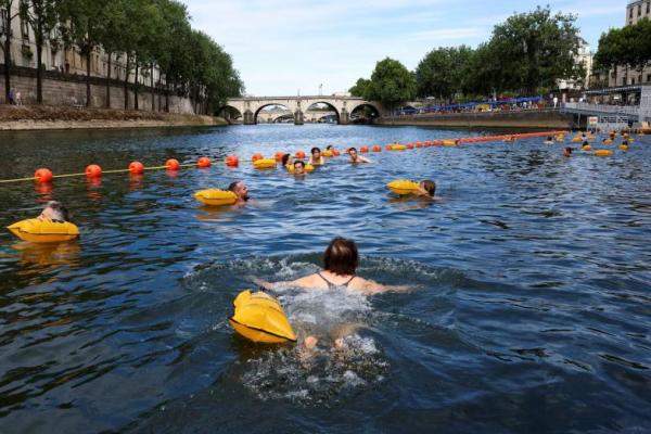 Orang-orang berenang di Sungai Seine di lokasi Bras Marie, di Paris, Prancis, 5 Juli 2025. REUTERS 