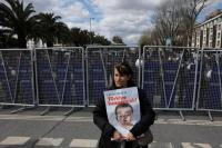 Seorang perempuan memegang plakat bergambar Wali Kota Istanbul Ekrem Imamoglu saat para pendukungnya berkumpul di dekat markas polisi kota di Istanbul, Turki, 19 Maret 2025. REUTERS