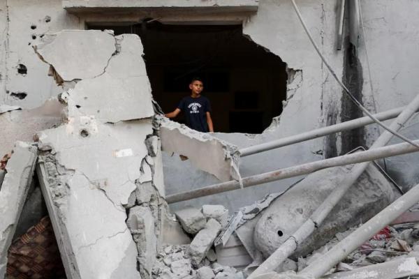 Seorang anak Palestina berdiri di lokasi serangan udara Israel semalam di Kota Gaza, 11 Juli 2025. REUTERS 