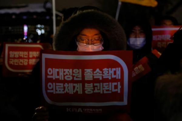 Seorang dokter memegang slogan dalam protes menentang rencana penerimaan lebih banyak mahasiswa ke sekolah kedokteran, di depan Kantor Kepresidenan di Seoul, Korea Selatan, 22 Februari 2024. REUTERS 