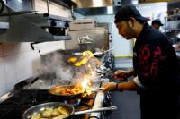 Chef Khimraj Nepali menyiapkan hidangan menggunakan resep dari Koki AI, di Restoran Trove di Dubai, Uni Emirat Arab, 8 Juli 2025. REUTERS