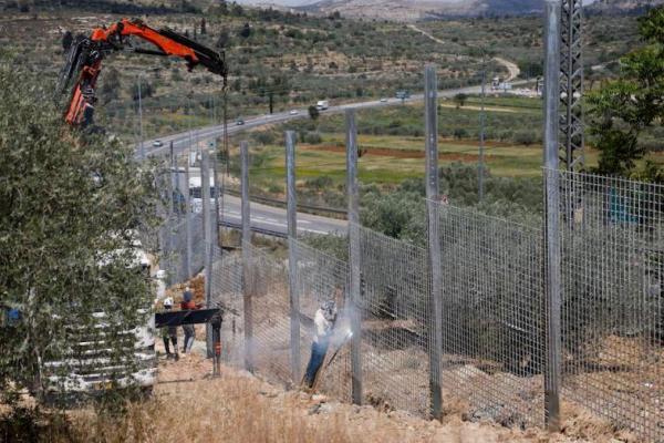 Pekerja membangun pagar yang dipasang oleh otoritas Israel di Sinjil, dekat Ramallah, di Tepi Barat yang diduduki Israel pada 5 Mei 2025. REUTERS 