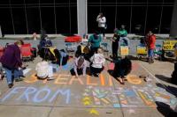Para demonstran menulis pesan selama unjuk rasa Bela Sekolah Kita untuk memprotes penutupan Departemen Pendidikan AS di luar gedungnya di Washington, AS, 21 Maret 2025. REUTERS