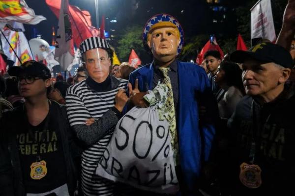 Para demonstran yang mengenakan kostum dan topeng mantan Presiden Brasil Jair Bolsonaro dan Presiden AS Donald Trump dalam protes menentang pengumuman tarif Trump, di Sao Paulo, Brasil, 10 Juli 2025. REUTERS 